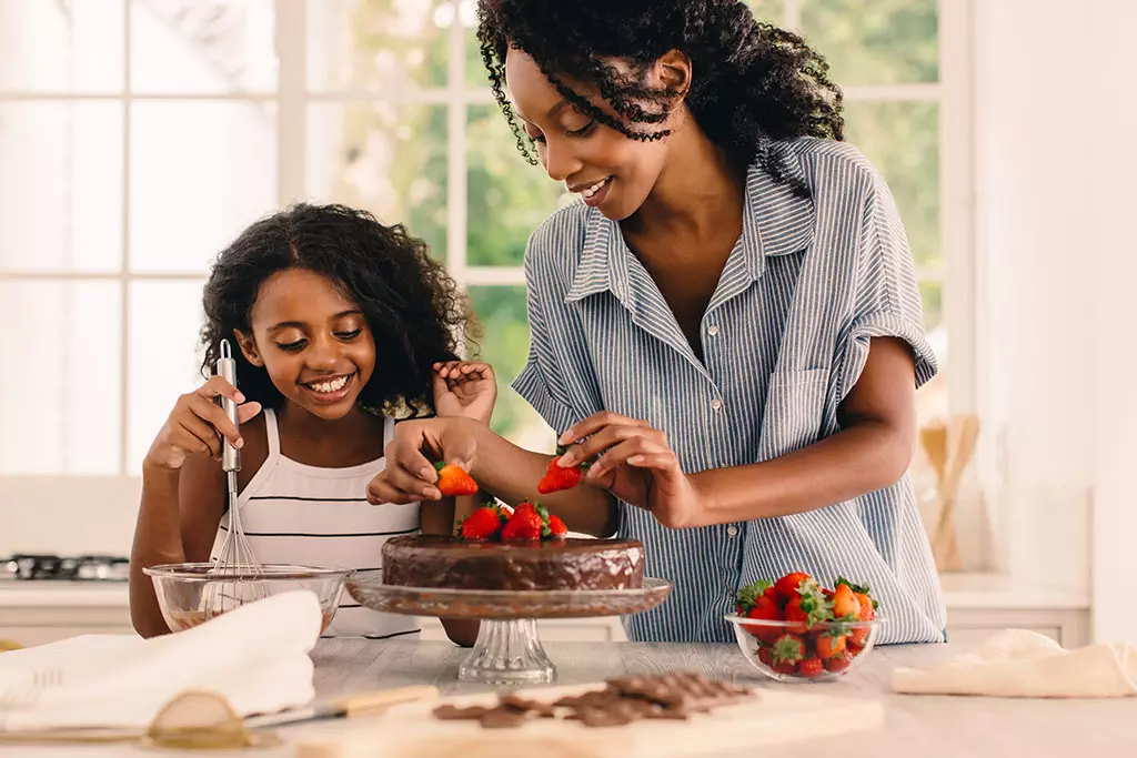 Lifestyle Mom and daughter making a cake